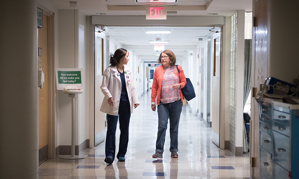 Mass General Imaging - Boston A clinician and a patient walk down a hall