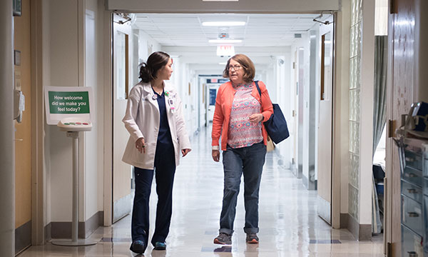 Mass General Imaging - Boston A clinician and a patient walk down a hall