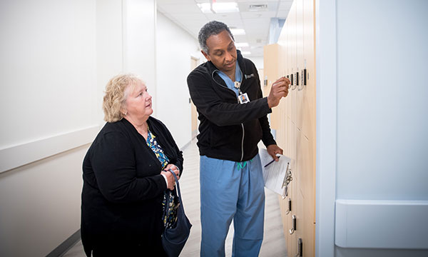 A technologist helps a patient with a locker