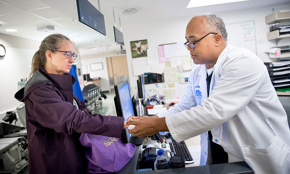 A care coordinator checks in a patient. A care coordinator checks in a patient.