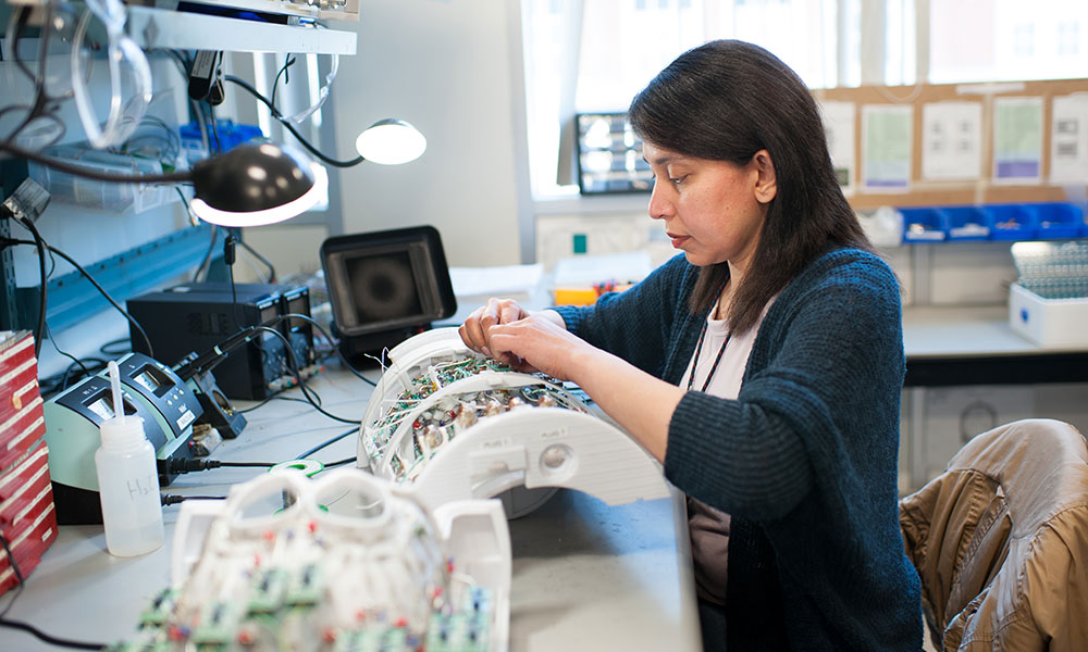 A researcher adjusts a piece of equipment in a laboratory A researcher adjusts a piece of equipment in a laboratory