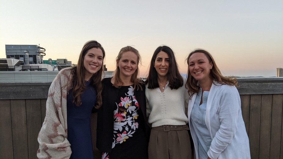 Four women on a rooftop with the sunset in the background. Four women on a rooftop with the sunset in the background.