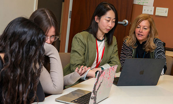 A group of four people working on laptops A group of four people working on laptops