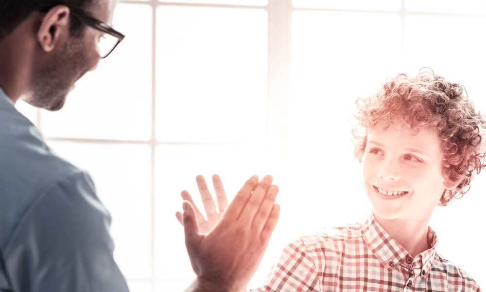 A boy high-fives a doctor A boy high-fives a doctor