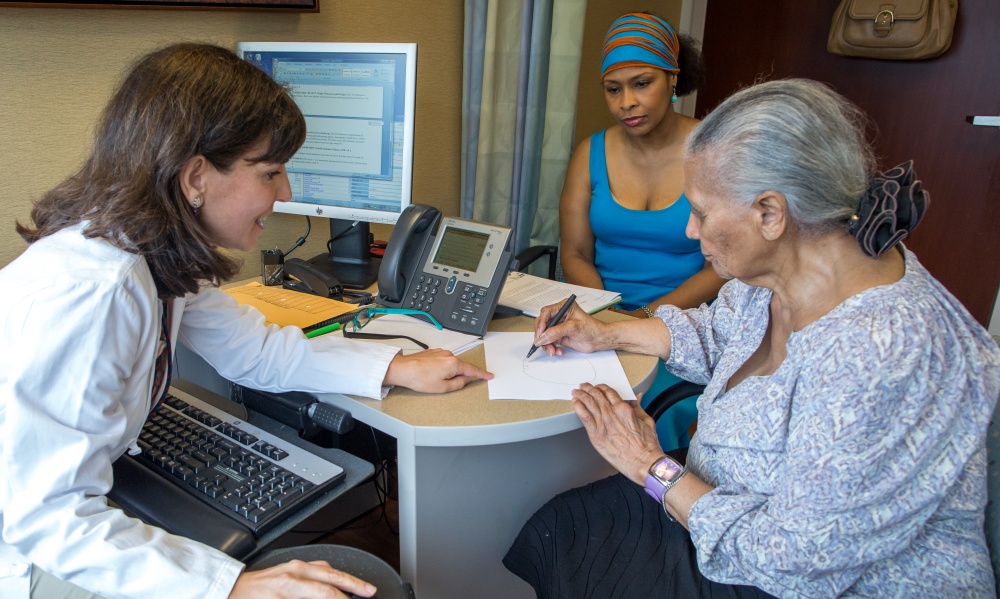 Teresa Gomez-Isla, MD speaks with a patient and family member Teresa Gomez-Isla, MD speaks with a patient and family member