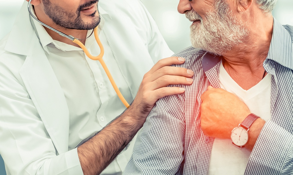 A doctor listening to an older male patient's lungs with a stethoscope A doctor listening to an older male patient's lungs with a stethoscope