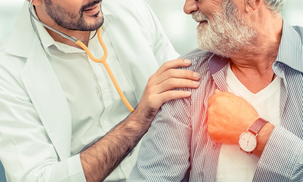 A doctor listening to an older male patient's lungs with a stethoscope A doctor listening to an older male patient's lungs with a stethoscope
