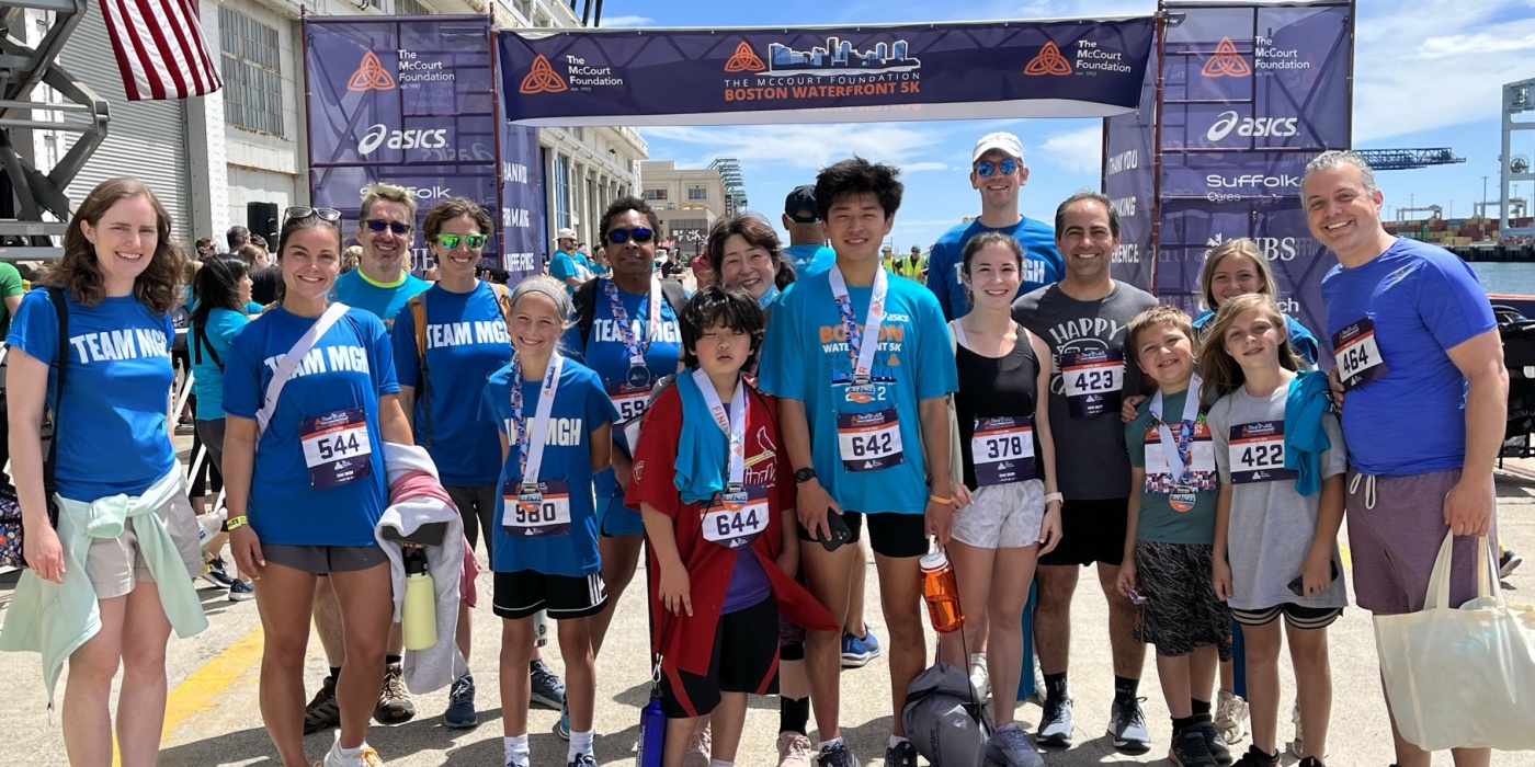 Team MGH runners smiling at the finish line of the McCourt Foundation Waterfront 5k