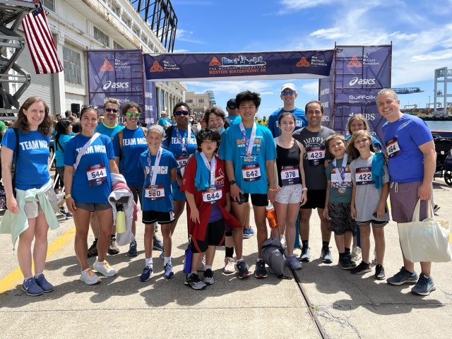 Team MGH runners smiling at the finish line of the McCourt Foundation Waterfront 5k