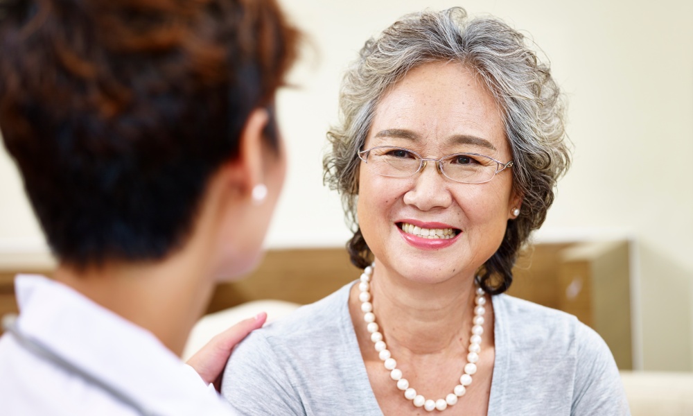Silver-haired woman consults with doctor Silver-haired woman consults with doctor