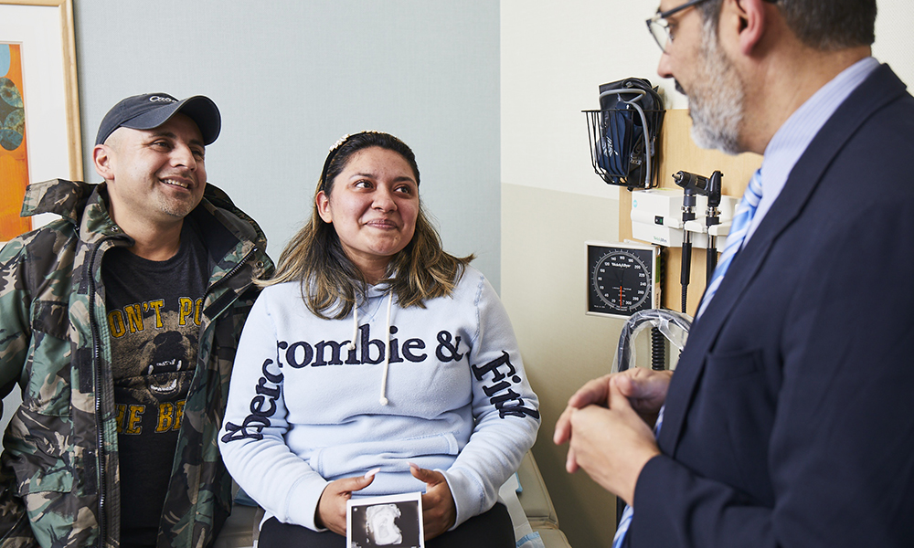 A doctor meets with a hopeful young couple. A doctor meets with a hopeful young couple.