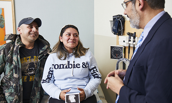 A doctor meets with a hopeful young couple. A doctor meets with a hopeful young couple.