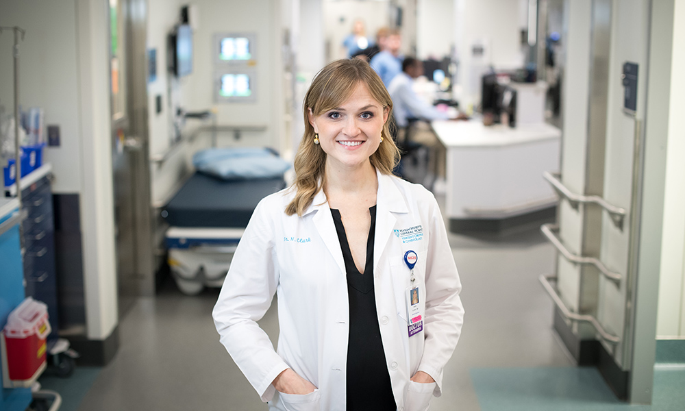 A young woman in a lab coat stands in a hospital hallway A young woman in a lab coat stands in a hospital hallway