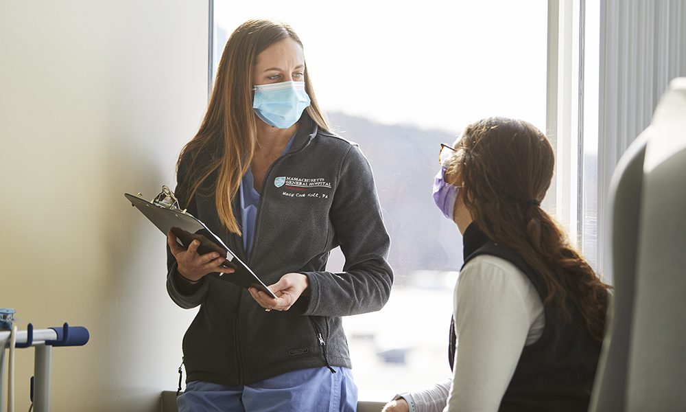 A picture of Macy Cook, PA, with the Hand & Arm Center in the Department of Orthopaedic Surgery, speaking to a patient A picture of Macy Cook, PA, with the Hand & Arm Center in the Department of Orthopaedic Surgery, speaking to a patient