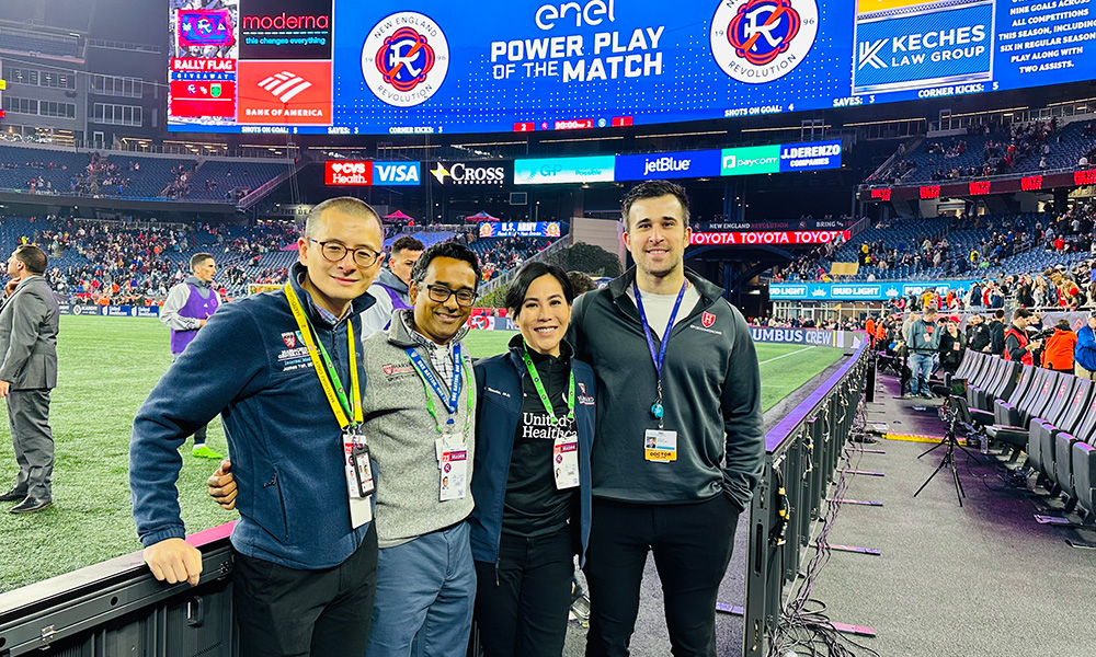 Medical Director for the New England Revolution and Director of the Mass General Brigham Women’s Sports Medicine program, Miho Tanaka, MD, PhD, poses with team doctor, Ashwin Babu, MD, and two Mass General Fellows following a Revolution game. Medical Director for the New England Revolution and Director of the Mass General Brigham Women’s Sports Medicine program, Miho Tanaka, MD, PhD, poses with team doctor, Ashwin Babu, MD, and two Mass General Fellows following a Revolution game.