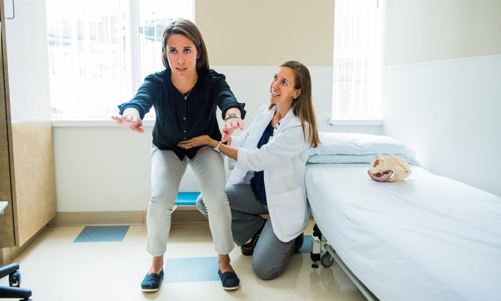 A physical therapist guides a patient through an exercise. A physical therapist guides a patient through an exercise.