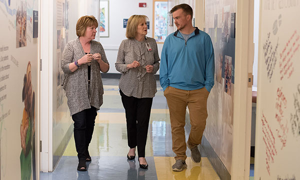 Social worker speaking with mother and son in hallway. Social worker speaking with mother and son in hallway.