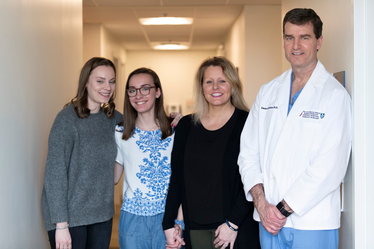 A mother and her two daughters next to their doctor