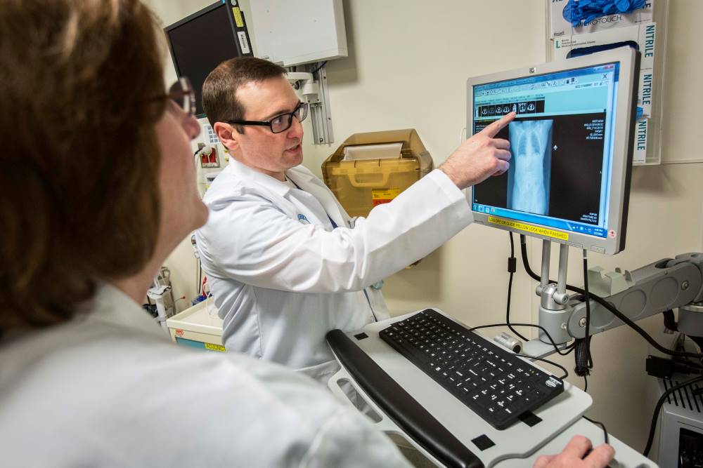 Alice Gervasini, RN, PhD (left), and Chris DePesa, RN (right), discuss a patient's care in the Trauma Emergency Department.
