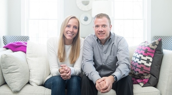 A patient and living liver donor seated on a couch, smiling. A patient and living liver donor seated on a couch, smiling.
